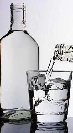 Pouring a glass of vodka, vodka bottle beside it