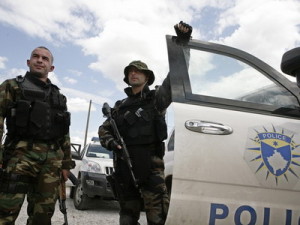 Members of the Kosovo police special forces stand by the vehicle in the ethnically divided town of Mitrovica
