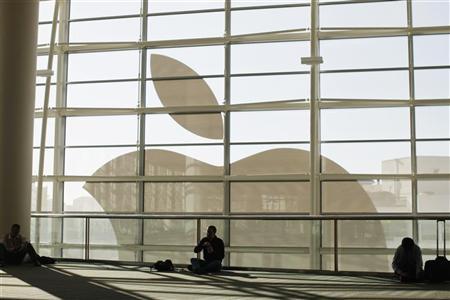 Attendees sit in front of an Apple logo during the Apple Worldwide Developers Conference 2012 in San Francisco