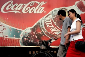 Image: couple walks by Coca-Cola sign