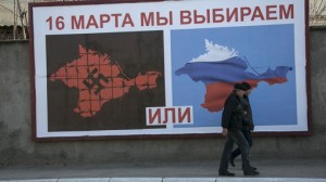 Man walk by a poster calling people to vote in the upcoming referendum, at the Crimean port of Sevastopol