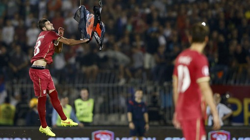 Mitrovic of Serbia grabs an Albanian flag that was flown over the pitch during their Euro 2016 Group I qualifying soccer match against Albania at the FK Partizan stadium in Belgrade